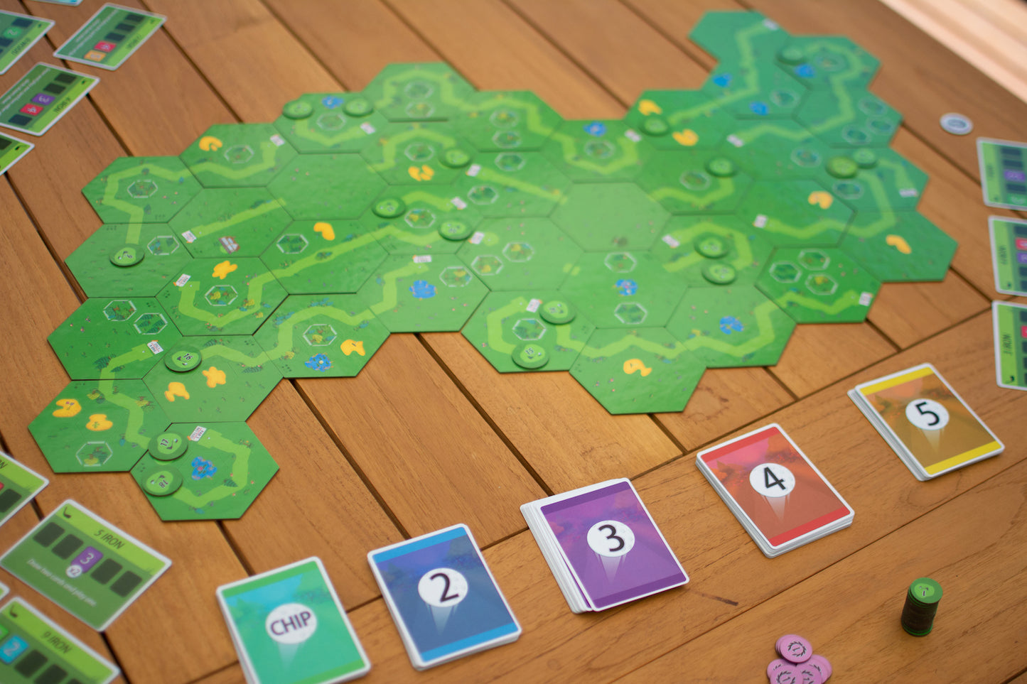 18 Holes game setup on a table. A course has been laid out with the modular tiles and the shot decks have been setup beside the board